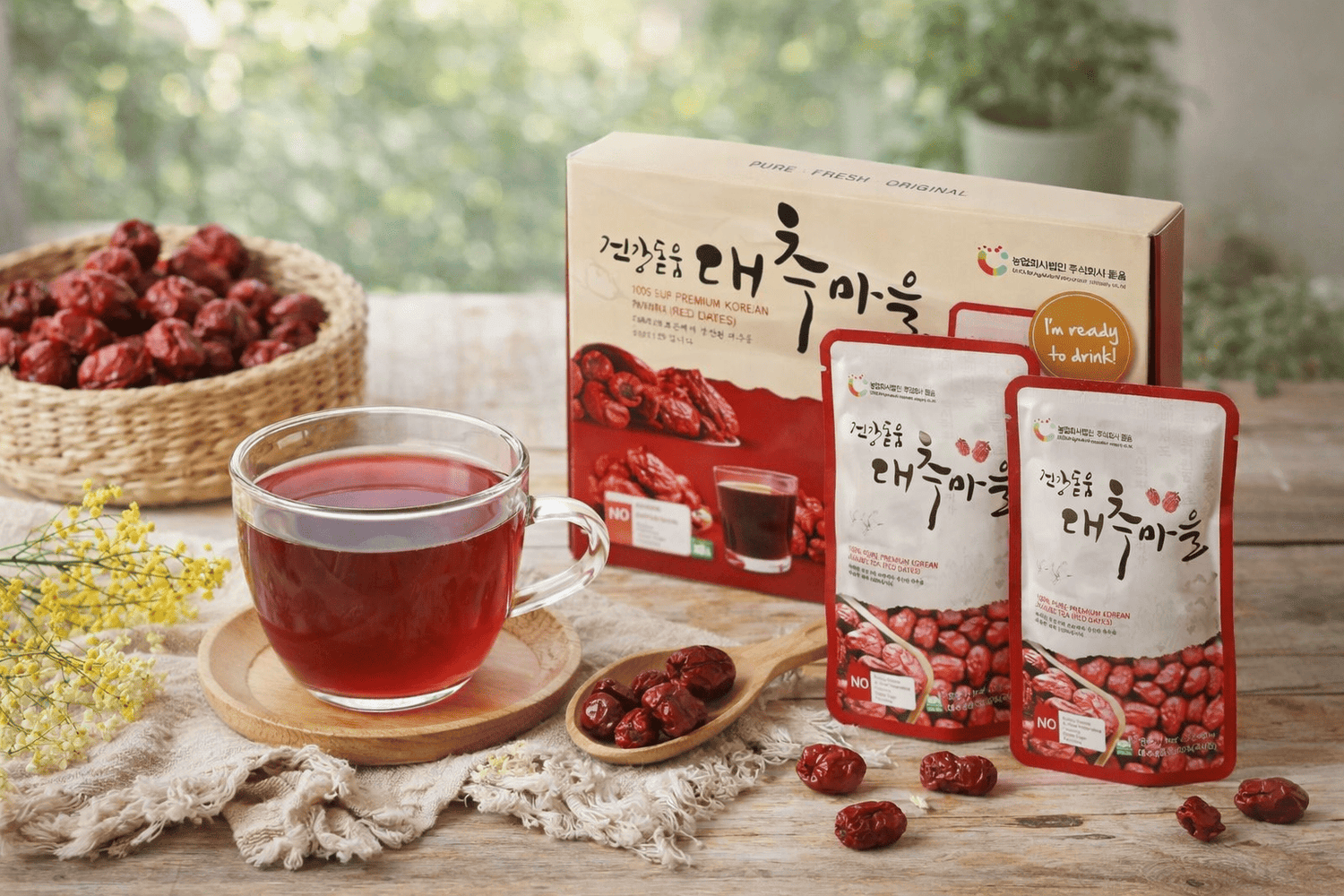 Secawan teh kurma merah Korea diletakkan di atas alas kayu bersama bungkusan produk dan kurma merah kering, dipersembahkan dalam suasana lembut dengan cahaya semula jadi.